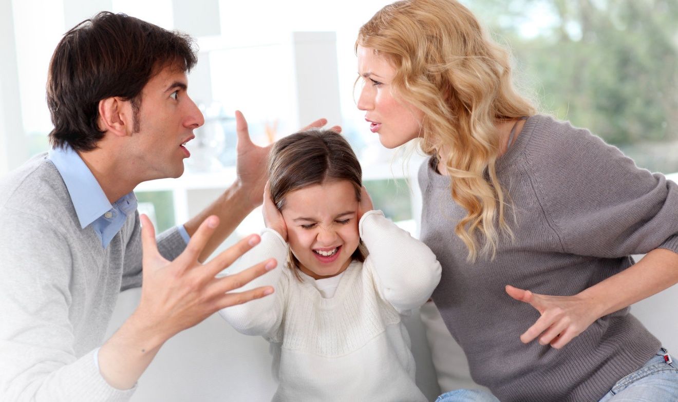 Parents arguing while their young daughter covers her ears